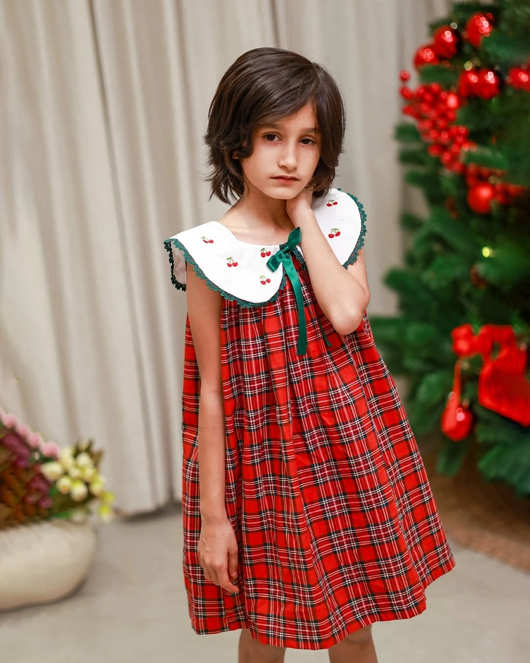 Child in red plaid dress with wide white collar