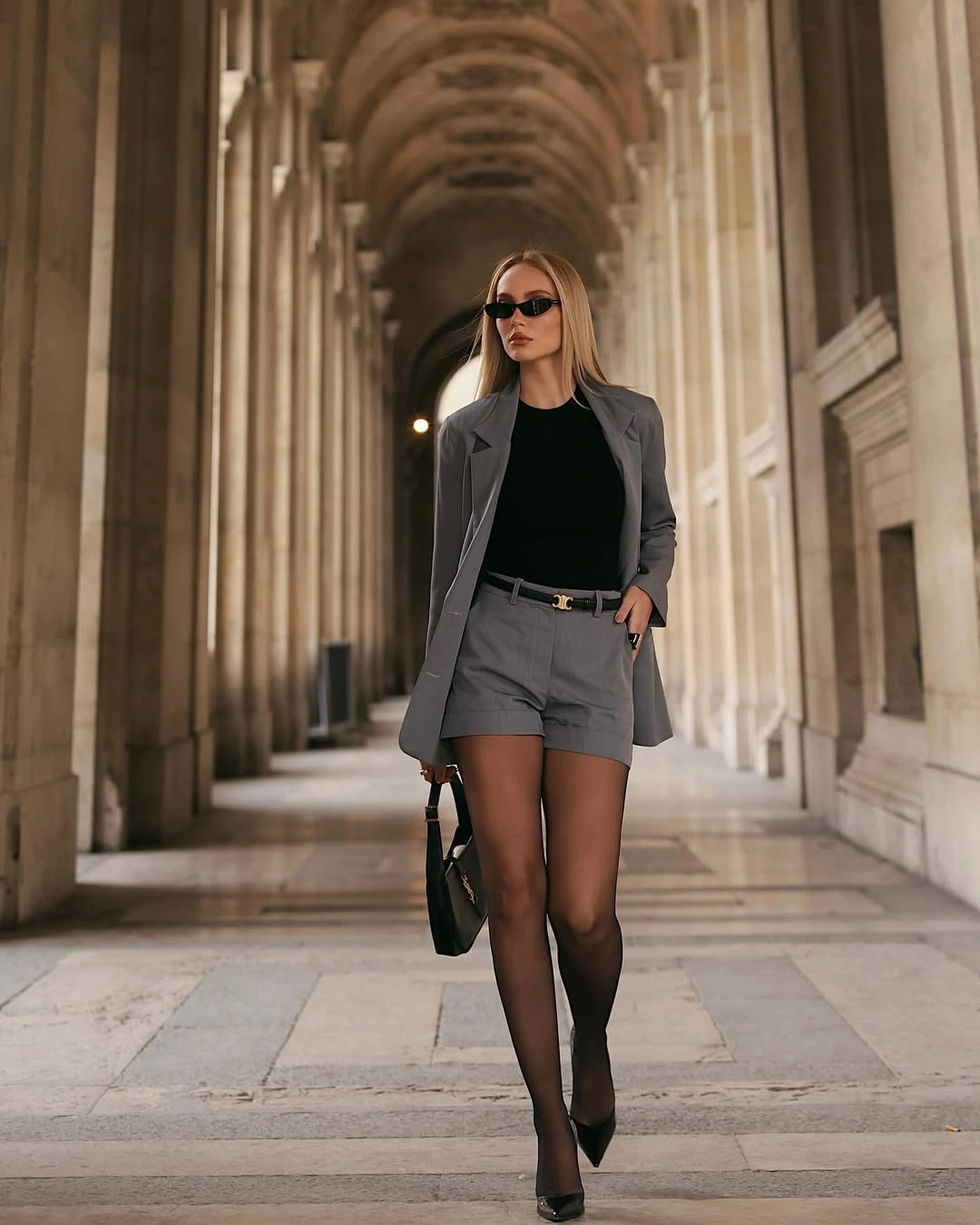 Gray blazer and shorts with black tights and pointed shoes