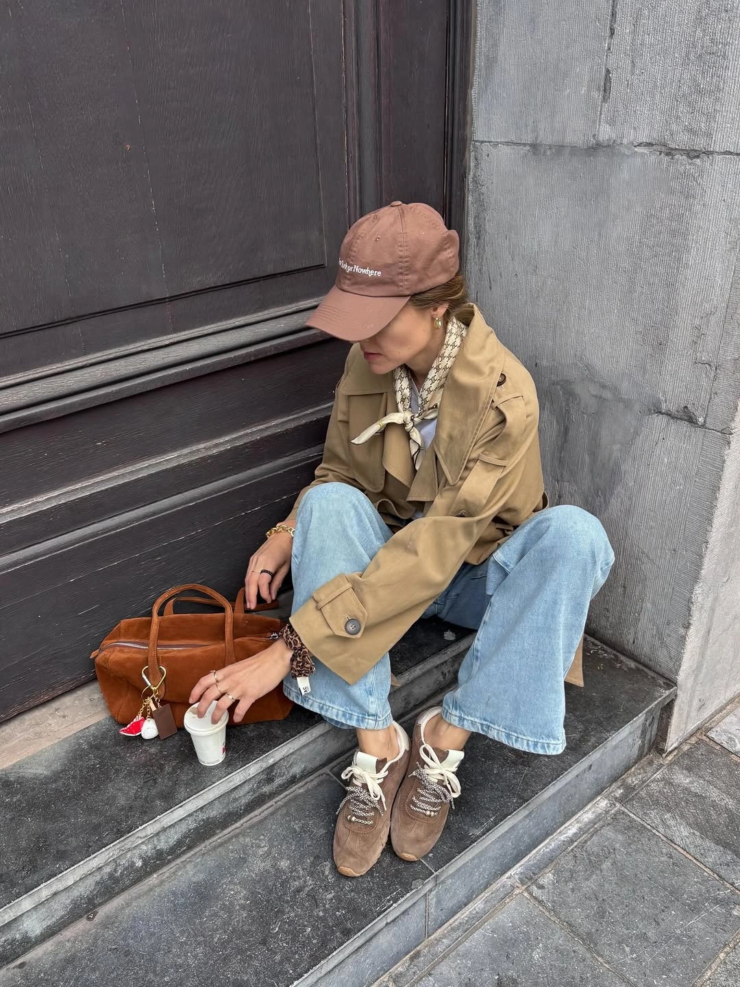 Tan cropped jacket, cap, wide jeans, tote, and sneakers