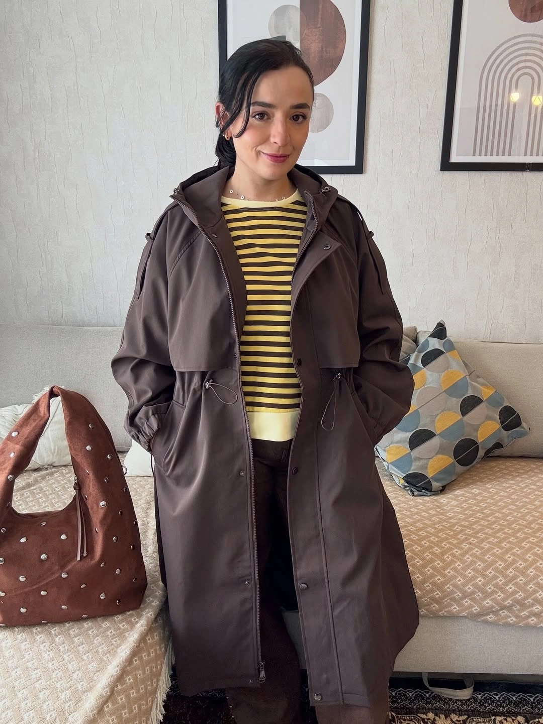 Dark drawstring outer layer with striped sweater and studded bag