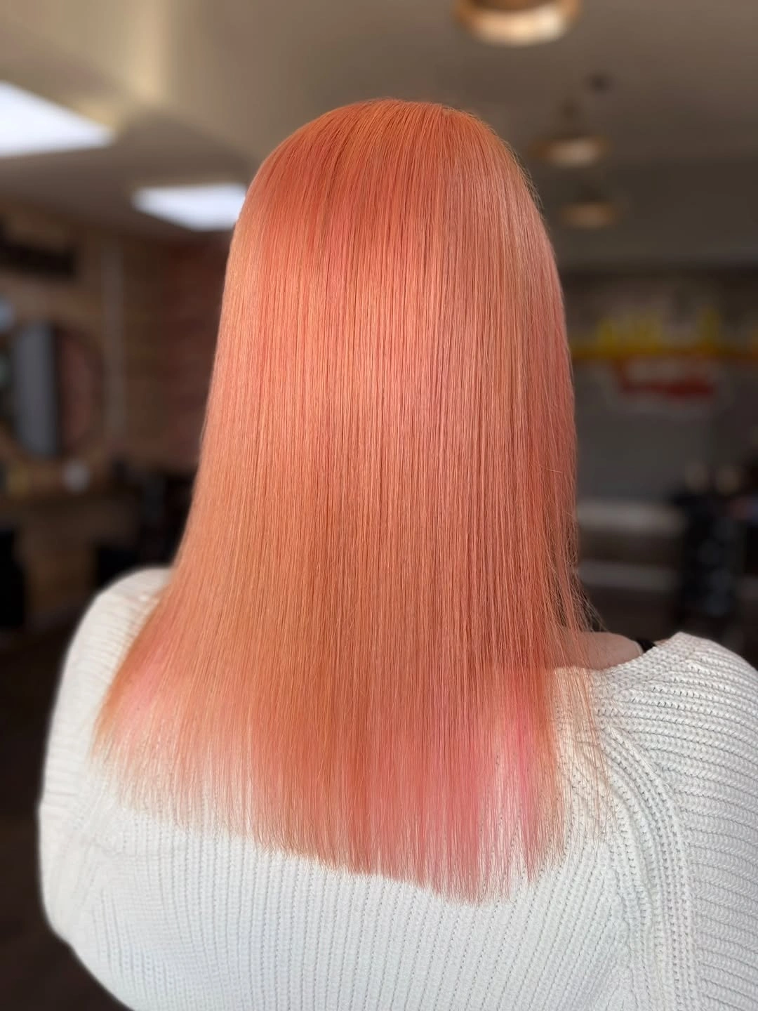 Straight peach-coral hair falling evenly to a clean lower edge.