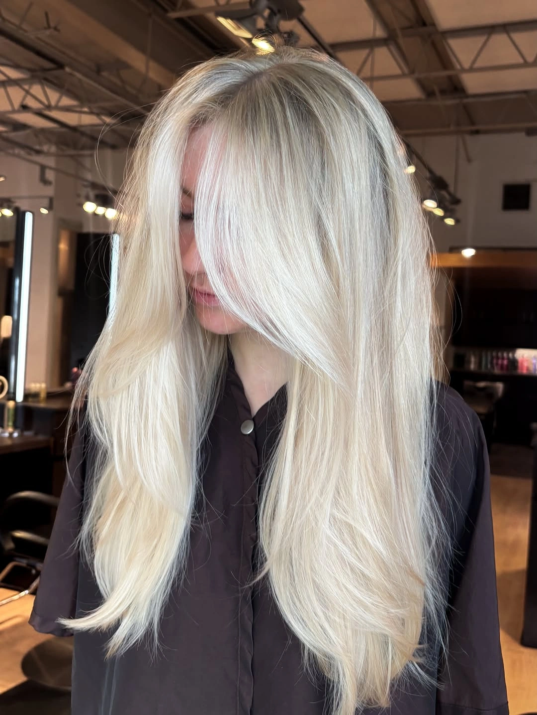 Long pale creamy blonde hair with center part and soft framing.