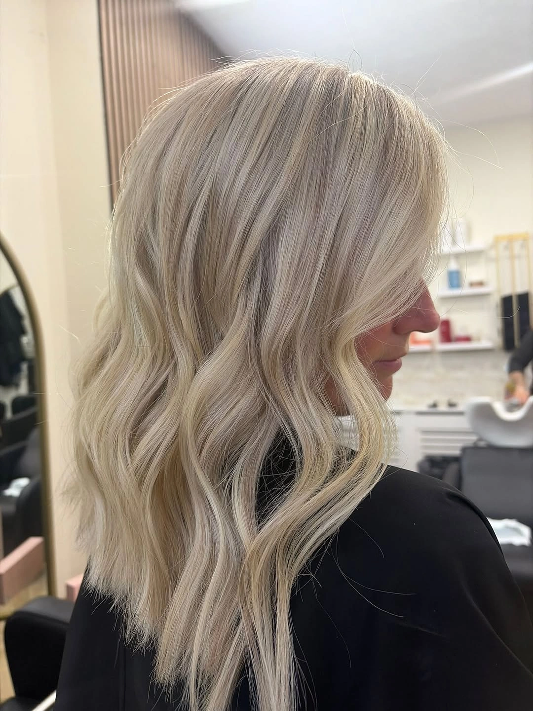 Pale blonde shoulder-length hair with soft waves viewed from the side.
