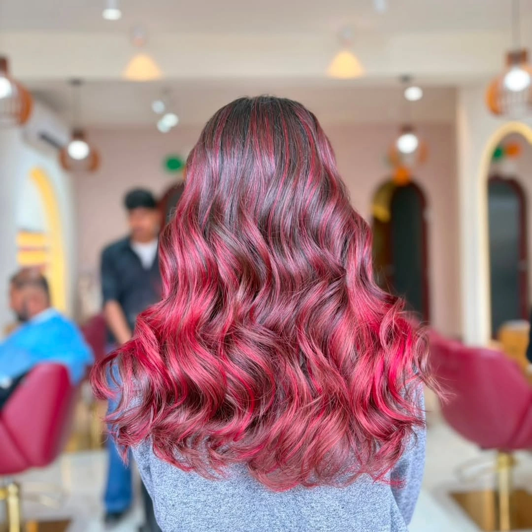 Long vivid magenta-pink hair with darker areas and defined waves.