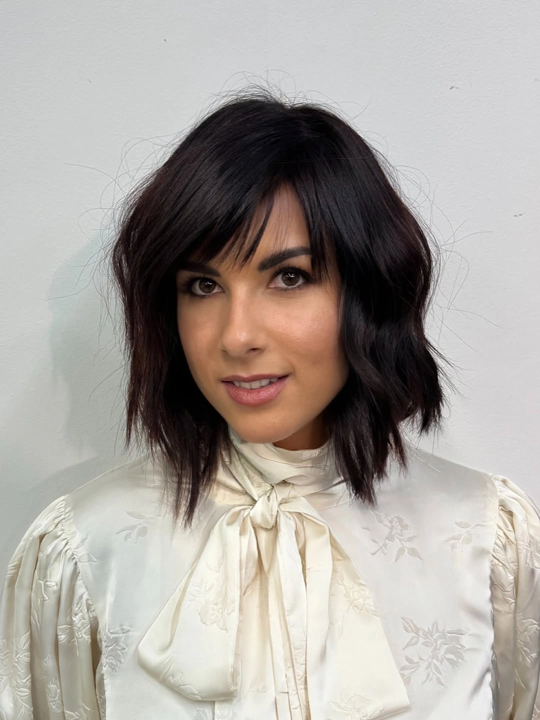 Dark short wavy hair with full bangs and textured ends