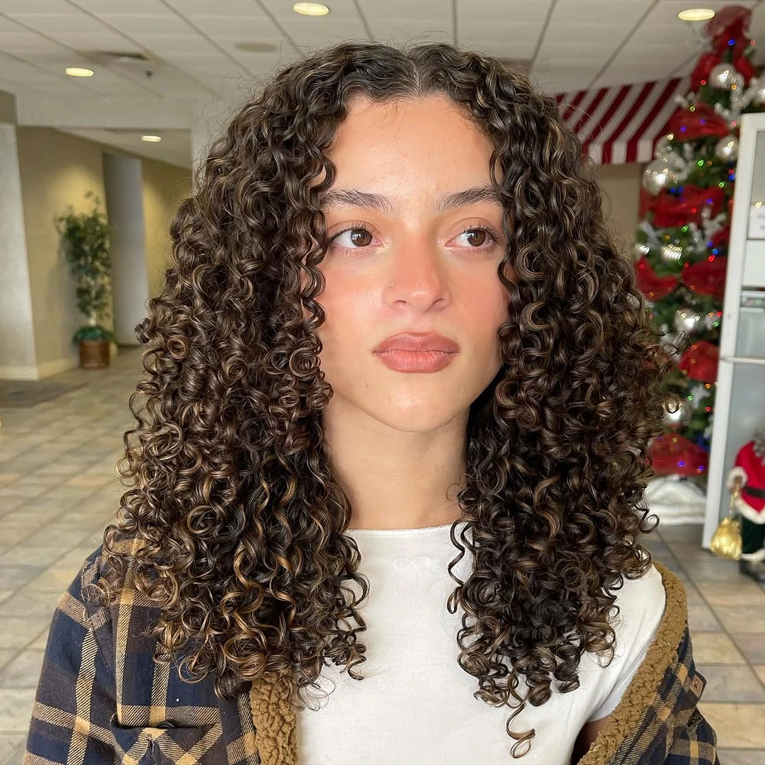 Dense tight curls forming a rounded medium-length silhouette