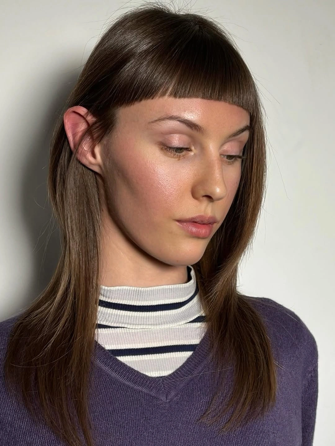 Long brown hair with very short blunt-looking bangs