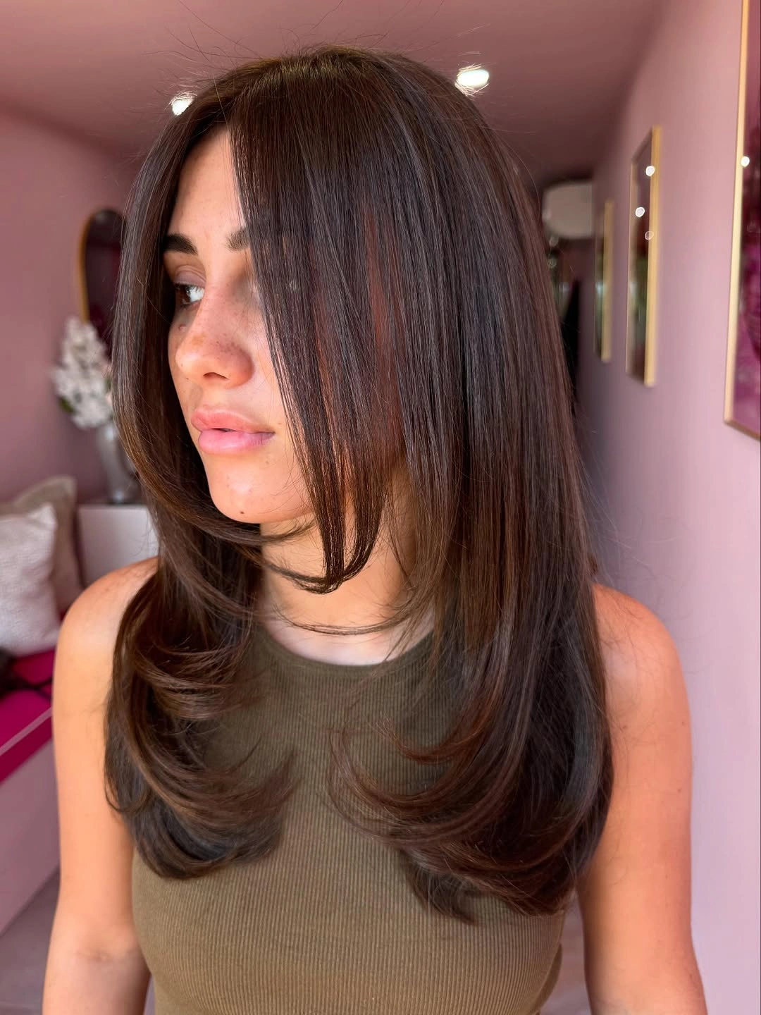 Long dark brown hair with center part and curved layered-looking ends