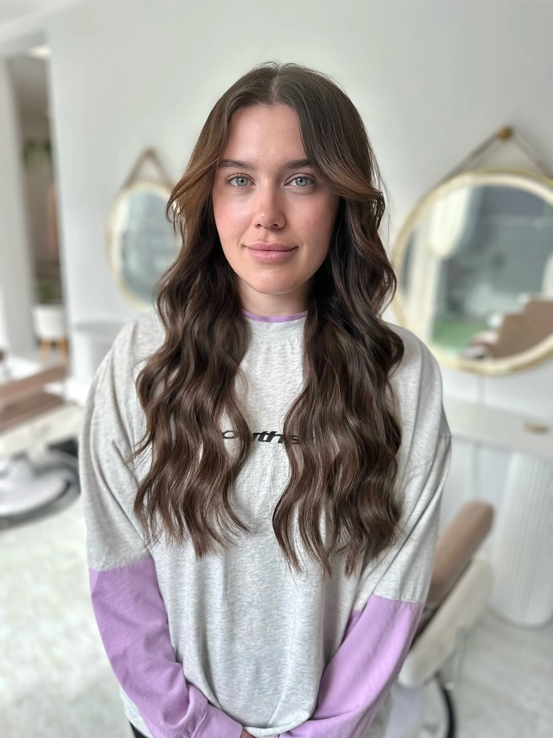 Very long brunette hair with center part, waves, and shorter front pieces