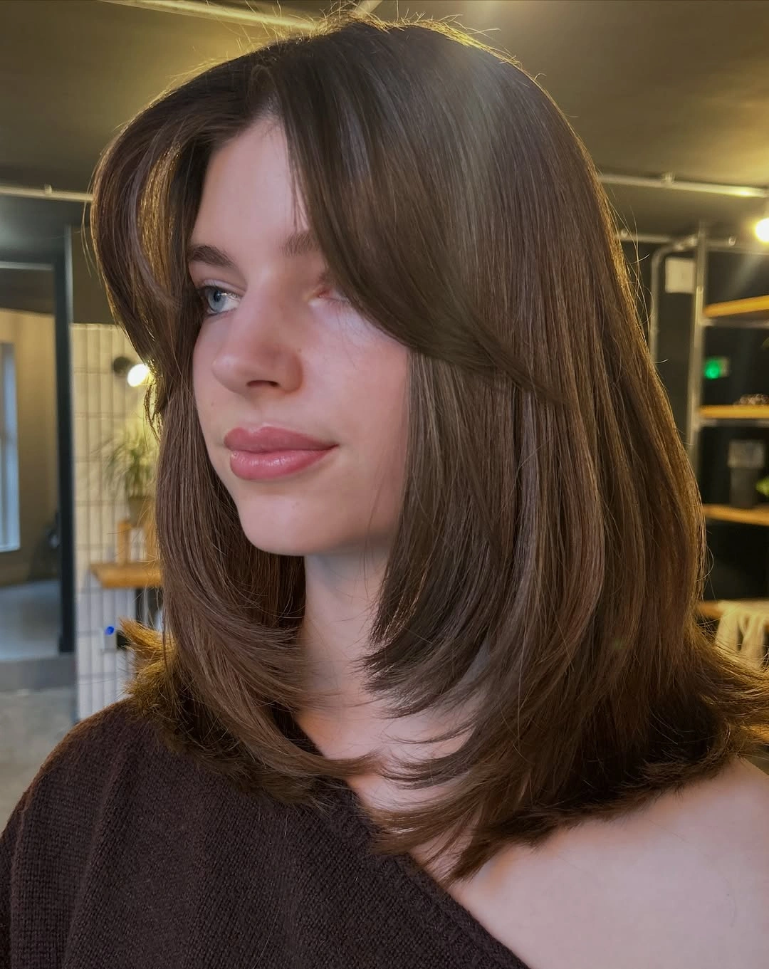 Brown shoulder-length hair with center-opening fringe and softly curved ends