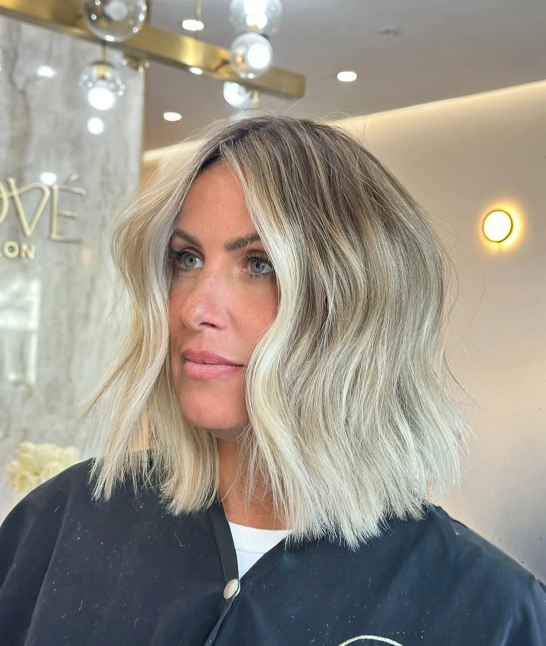 Pale blonde shoulder-length hair with center part and soft waves