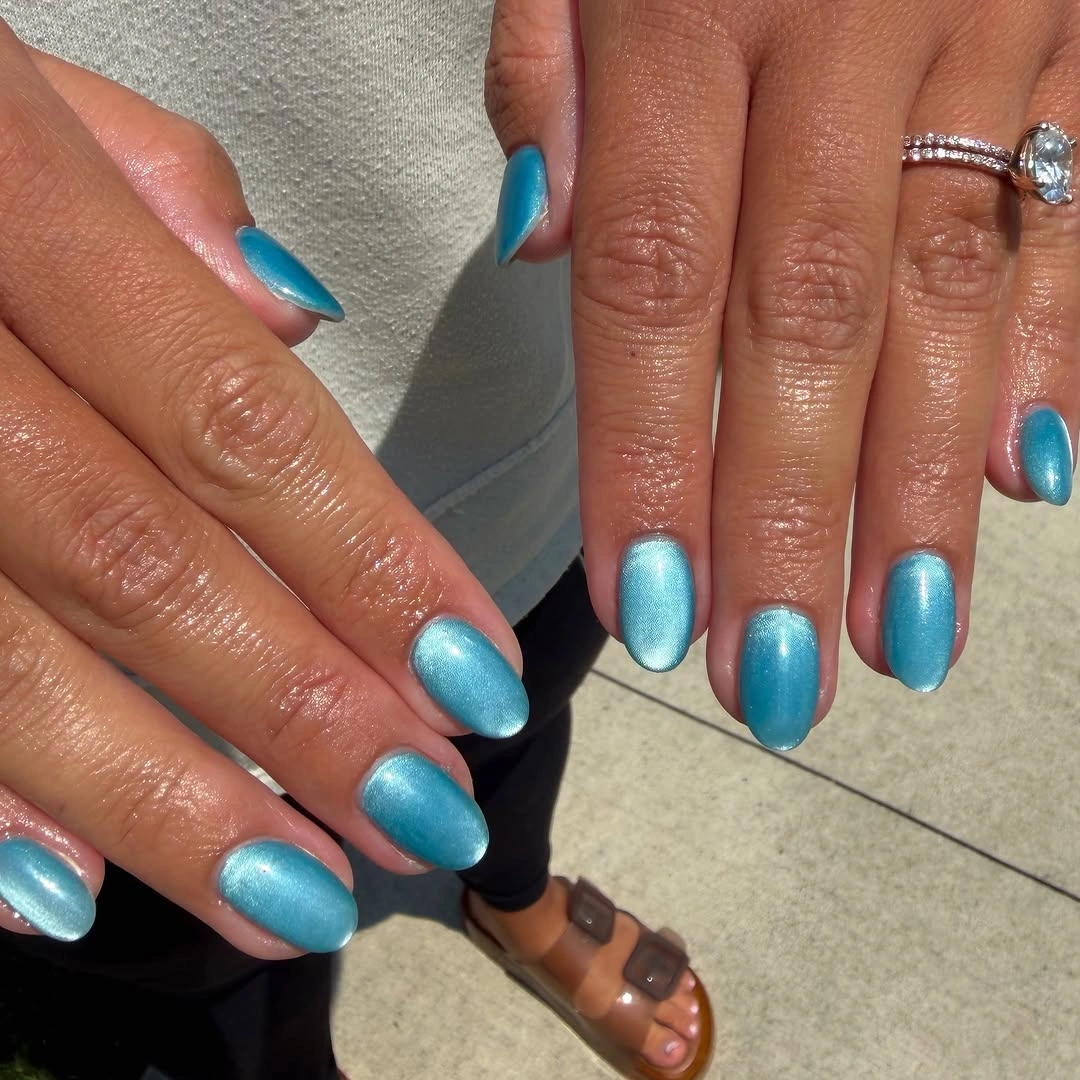 Short rounded turquoise nails with bright metallic-looking reflection