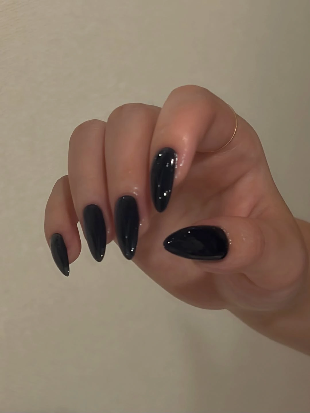 Tapered nails covered in glossy deep navy-black polish