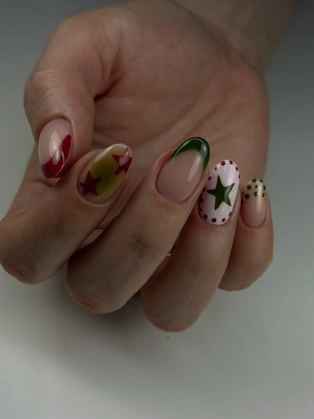 Almond nails with deep red, sheer pink, dots, and reflective edges