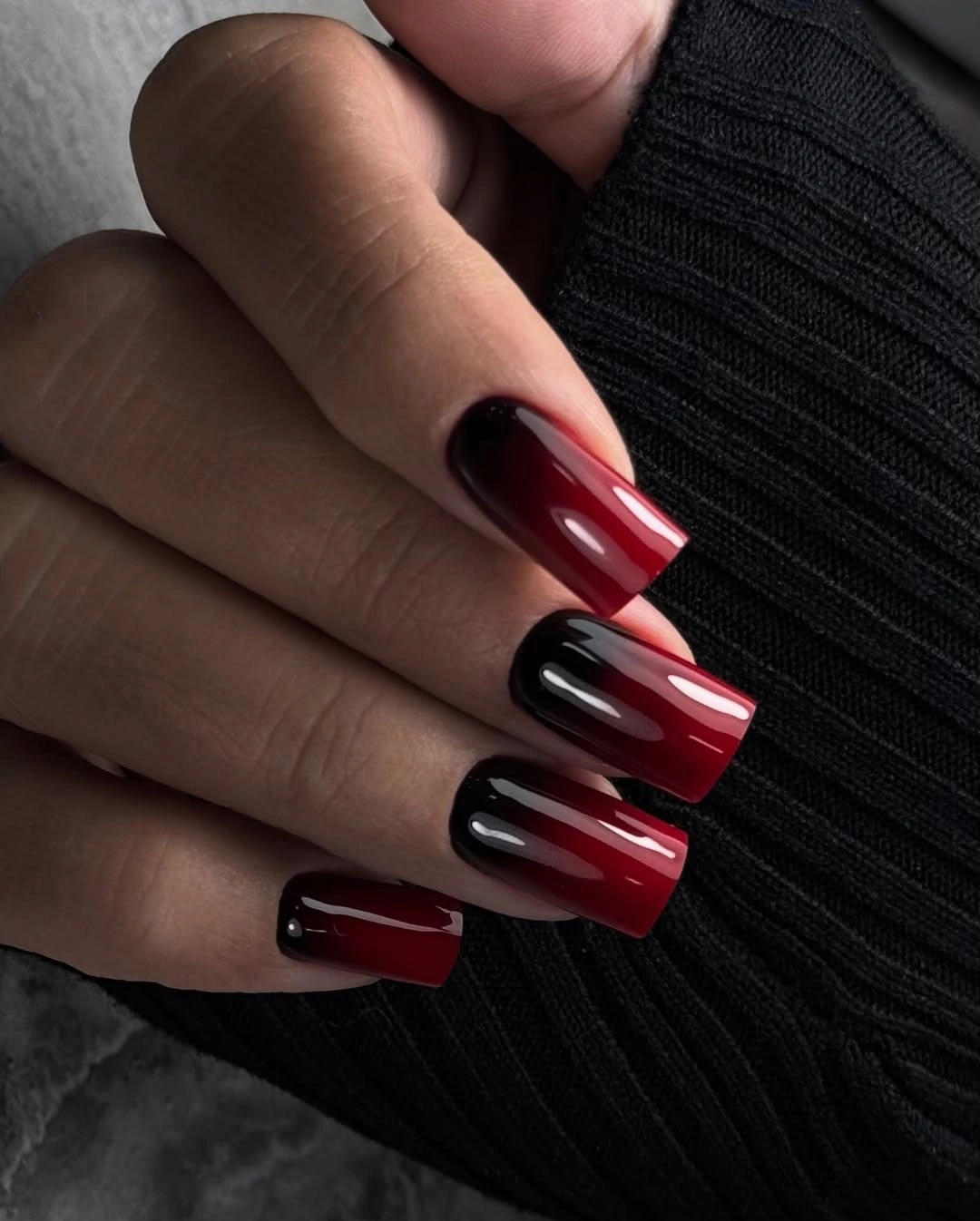 Short berry-red nails with darker dots and irregular red accents