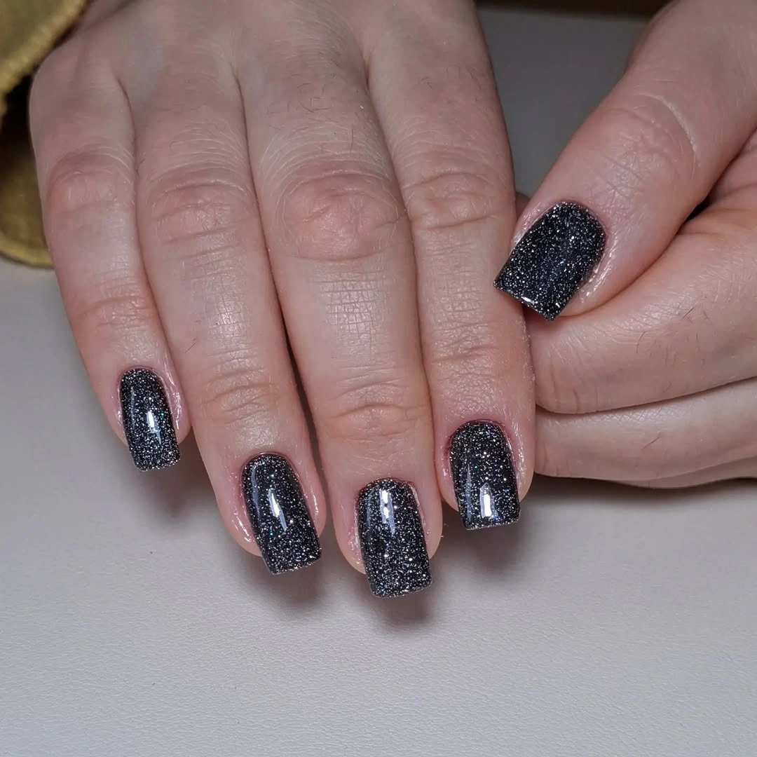 Almond nails with floral shapes, leopard-like spots, gold beads, and dark ridges