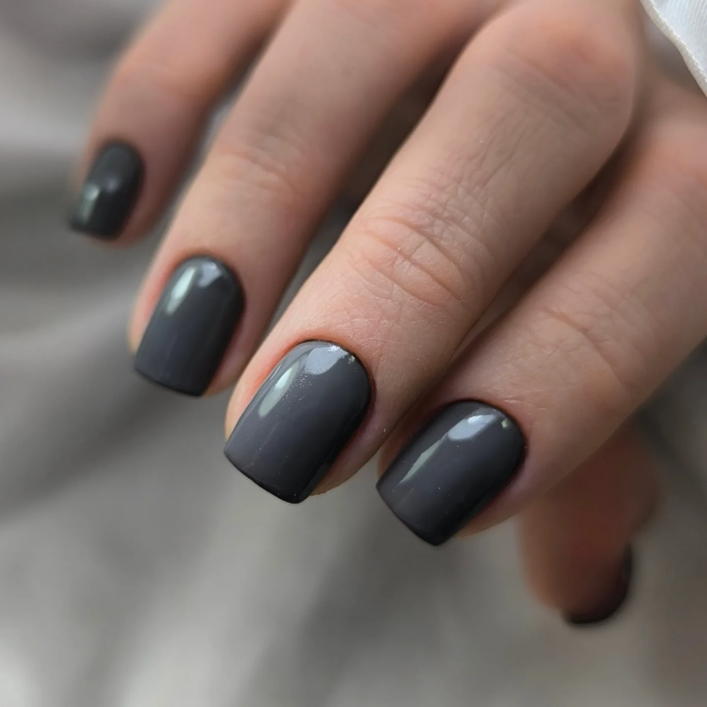 Short square pale nails with white curves and silver glitter lines