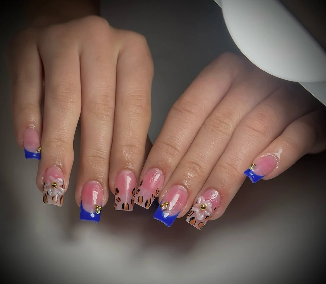 Square nude-pink nails with black leopard-like spots and silver accent