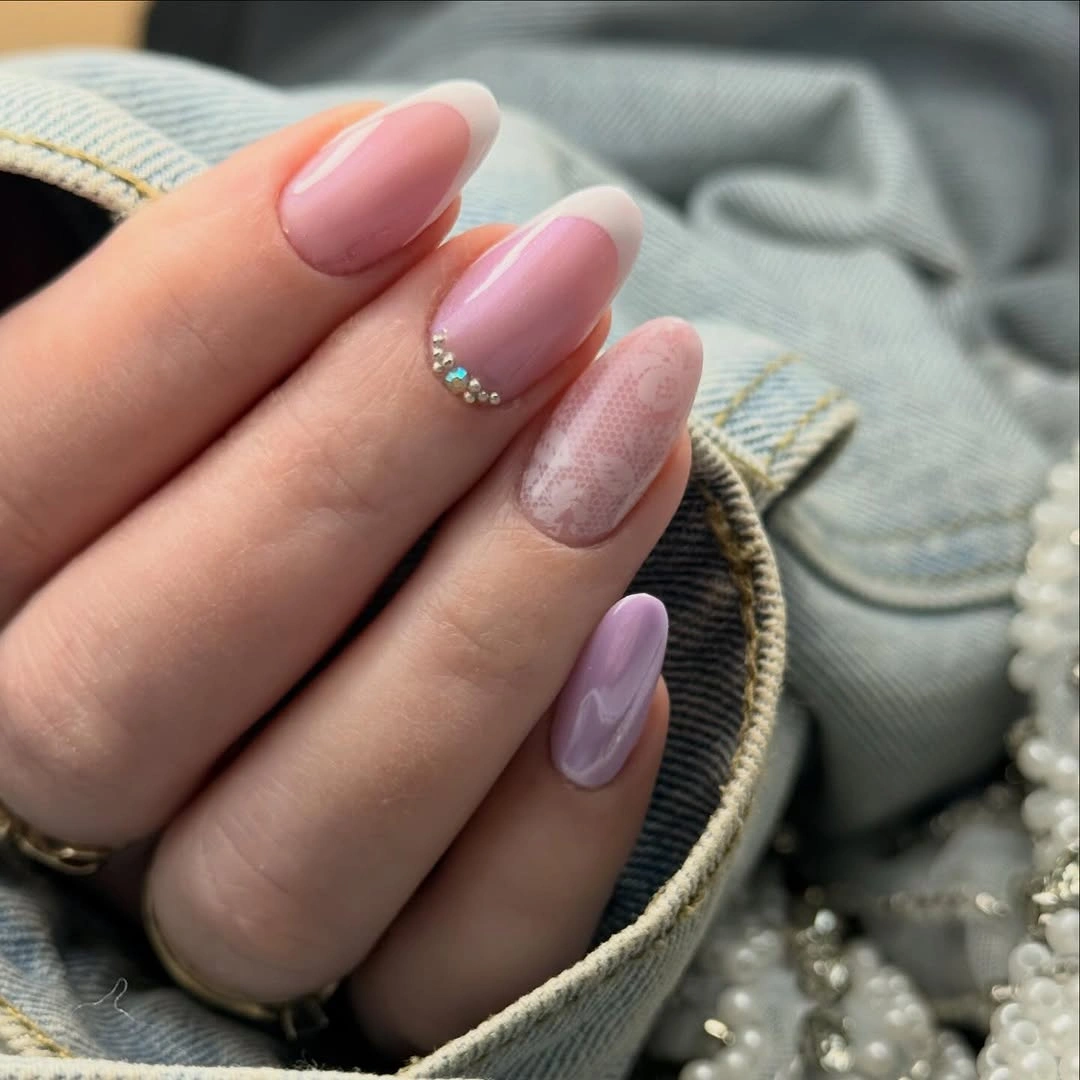 Pale almond nails with silver stars and tiny pink dots
