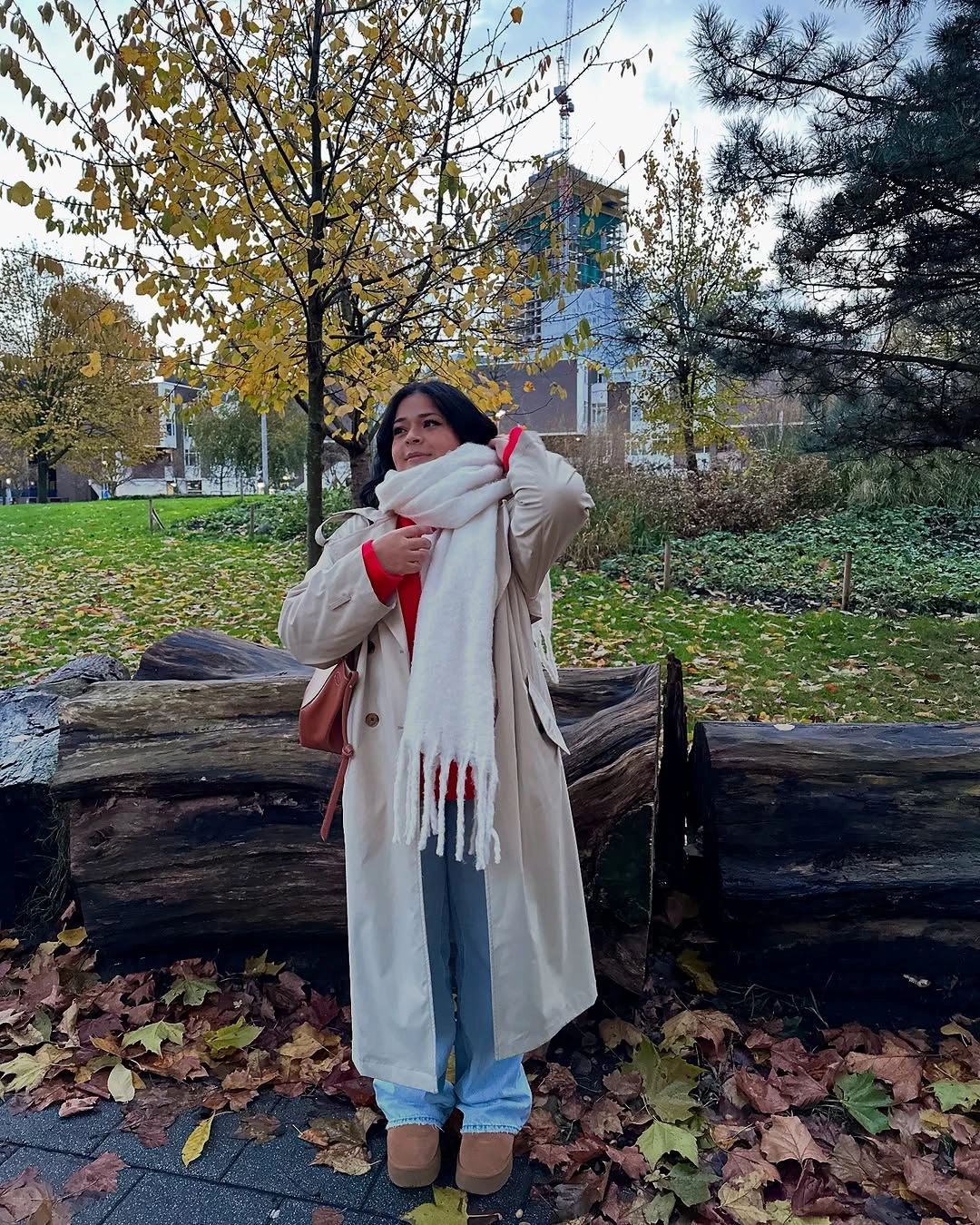 Off-white coat with oversized scarf, red fringe and blue jeans