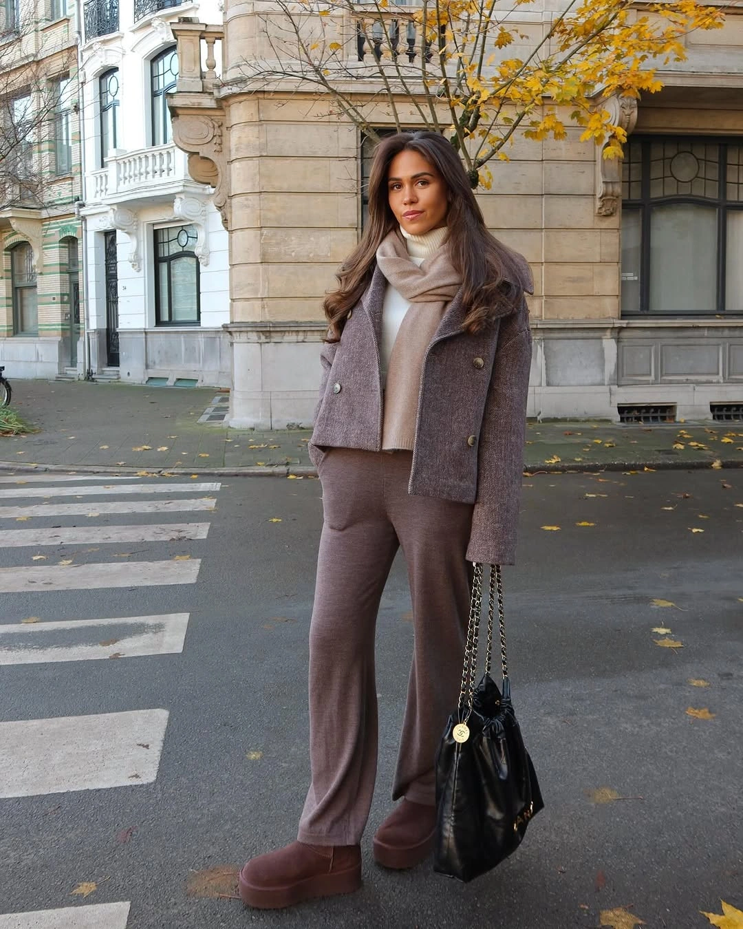 Cropped taupe-brown jacket with scarf, wide pants and black chain bag