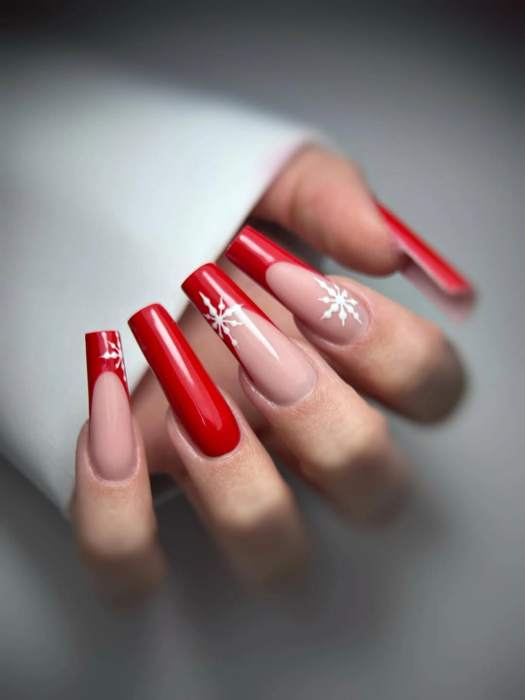 Short glossy red nails with small crystal-like base accents
