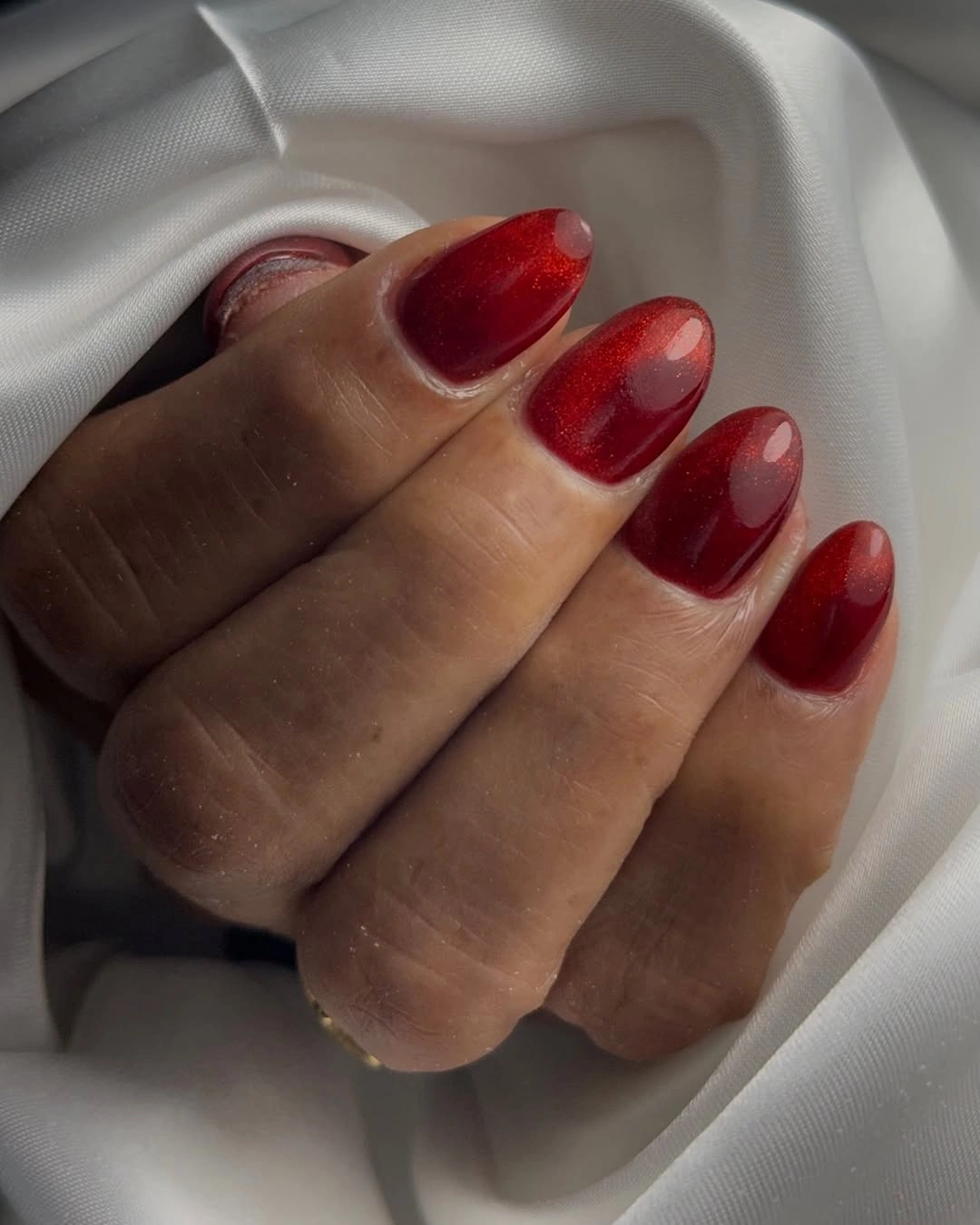 Long square glossy red nails with pale U-shaped arc details