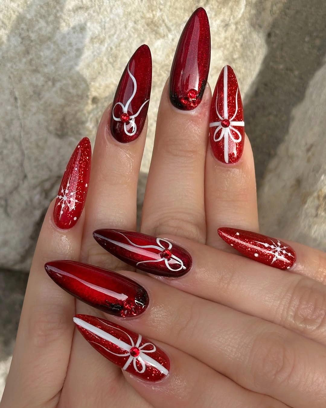 Short rounded-square red nails with pale pink glitter accent