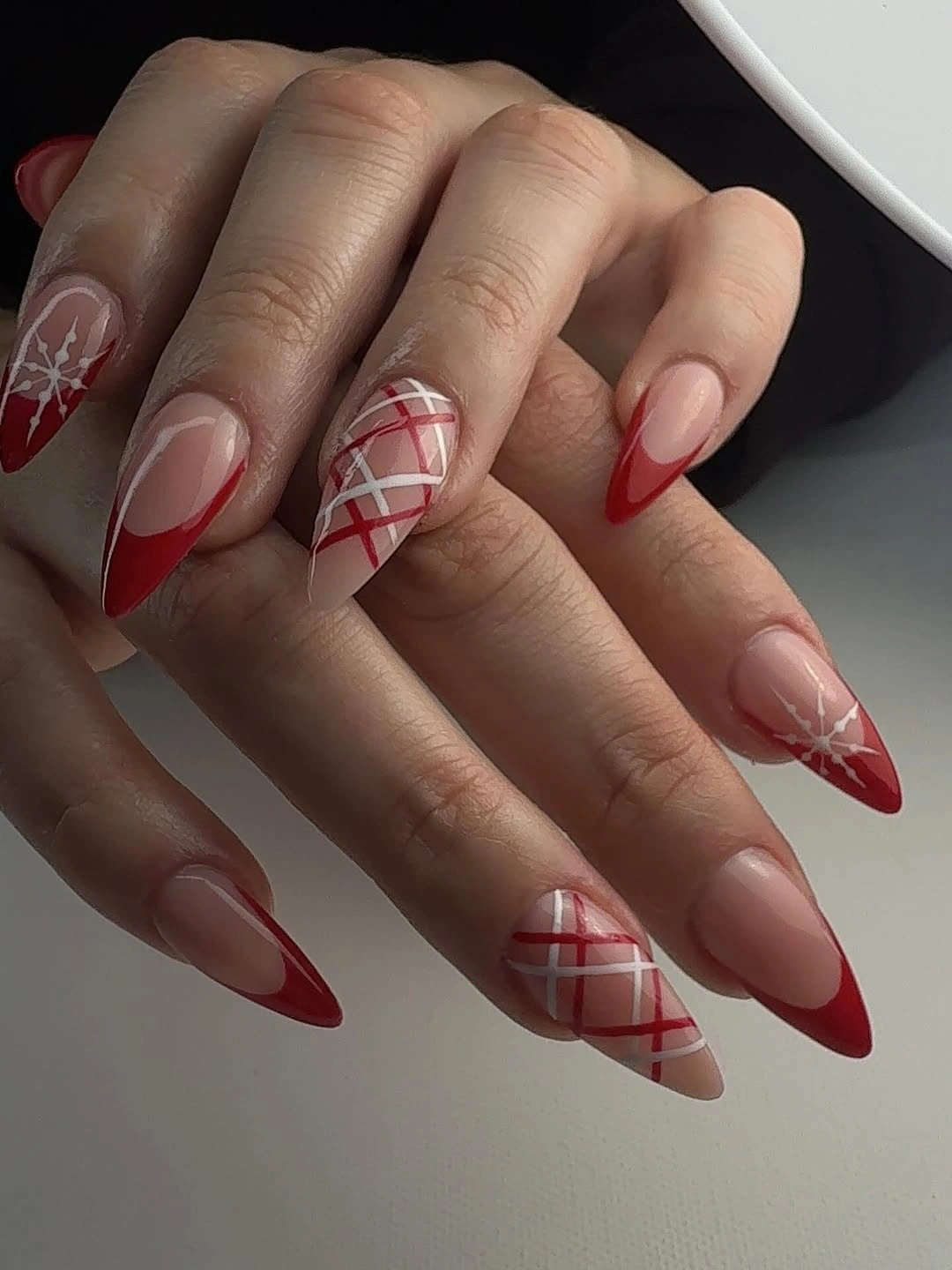 Almond nails with red glitter white snowflakes and pale accents