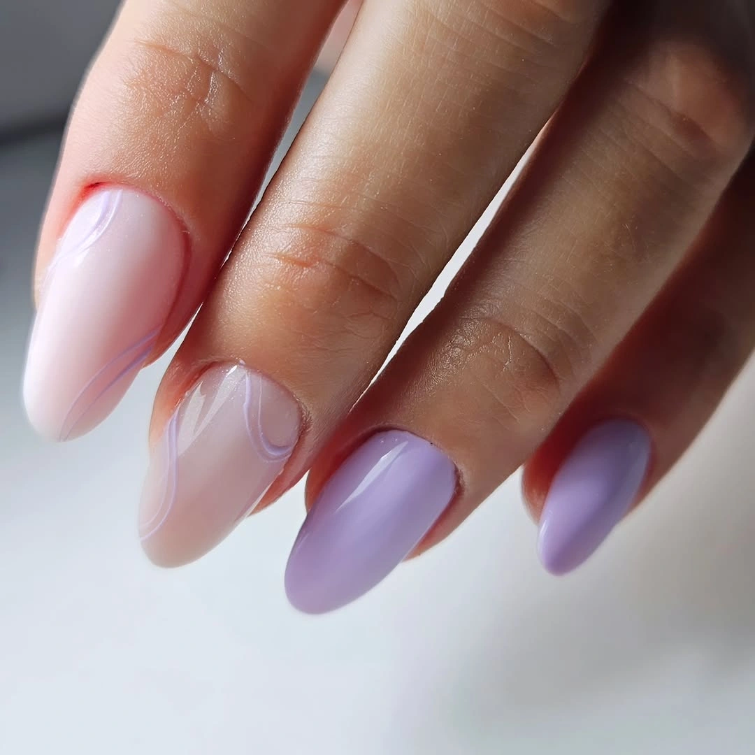 Lavender and pale pink almond nails with faint curved lines
