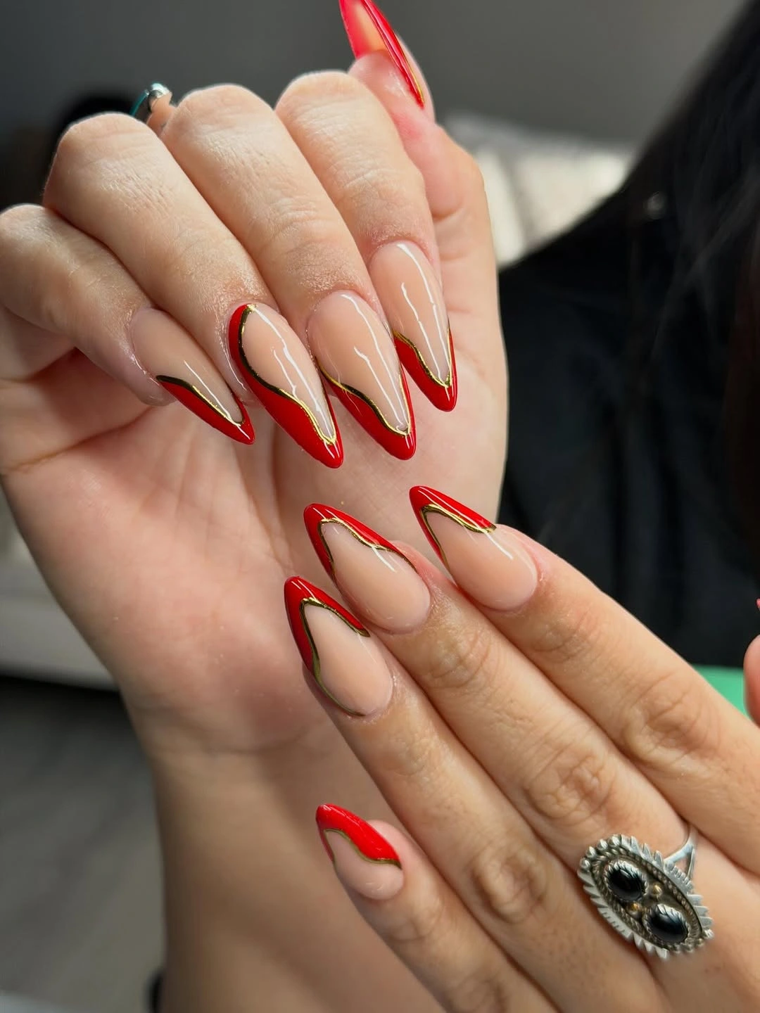 Long nude almond nails with red edges and gold lines