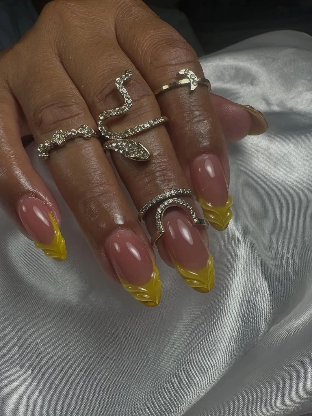 Nude pink almond nails with translucent yellow layered French tips