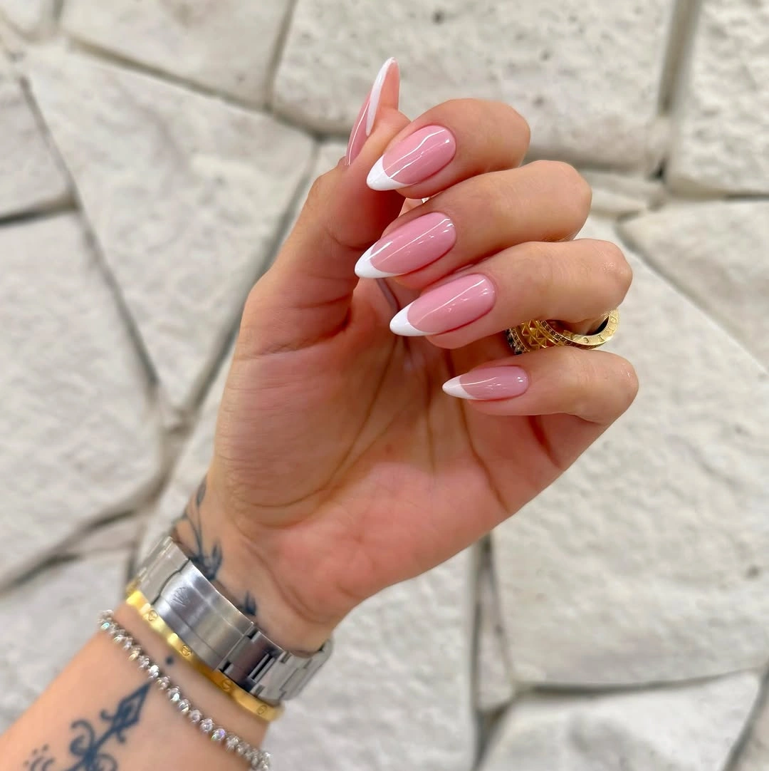 Glossy pink almond nails with clean white French tips