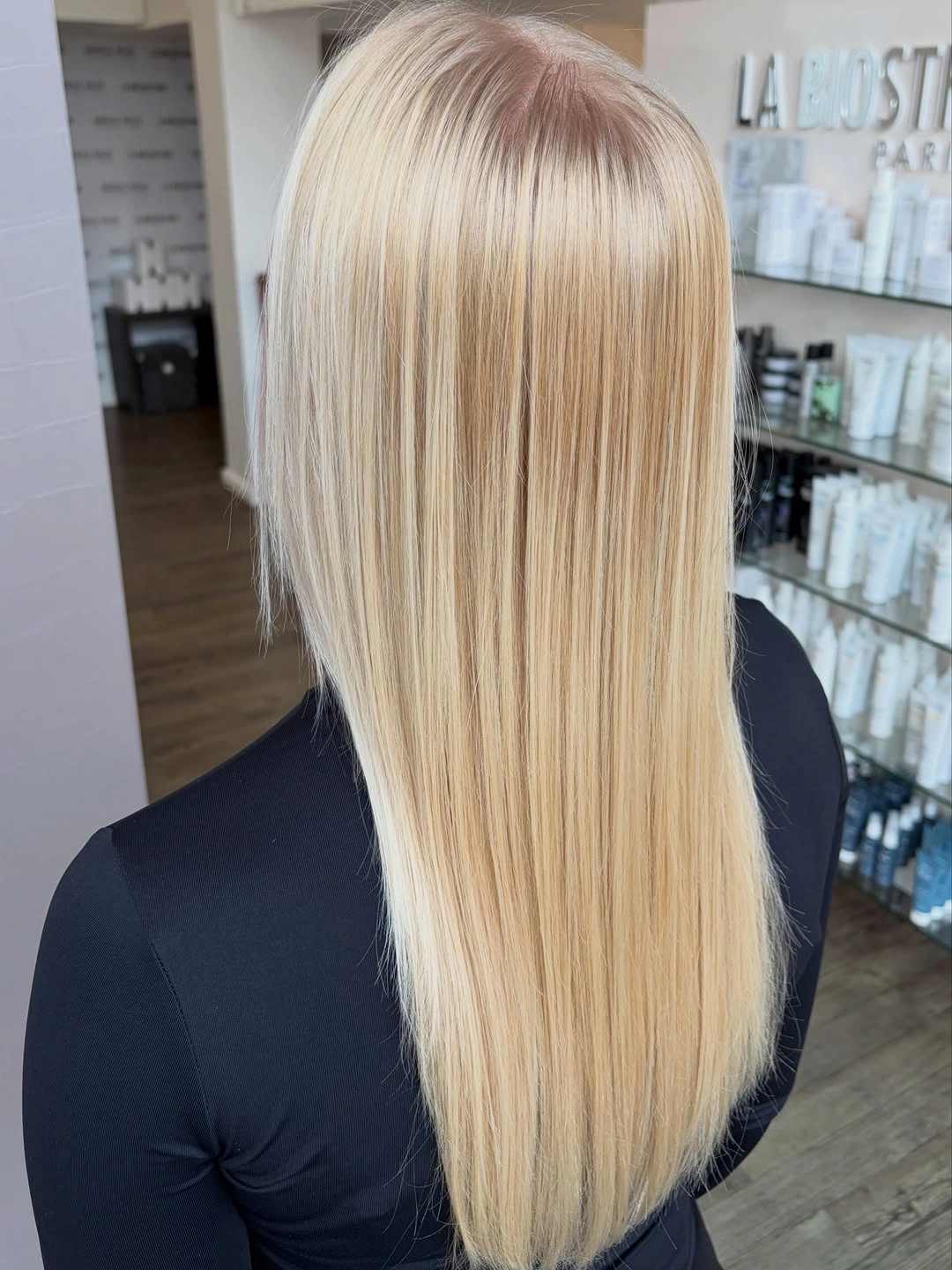 Long straight blonde hair with fine vertical highlights and narrow roots