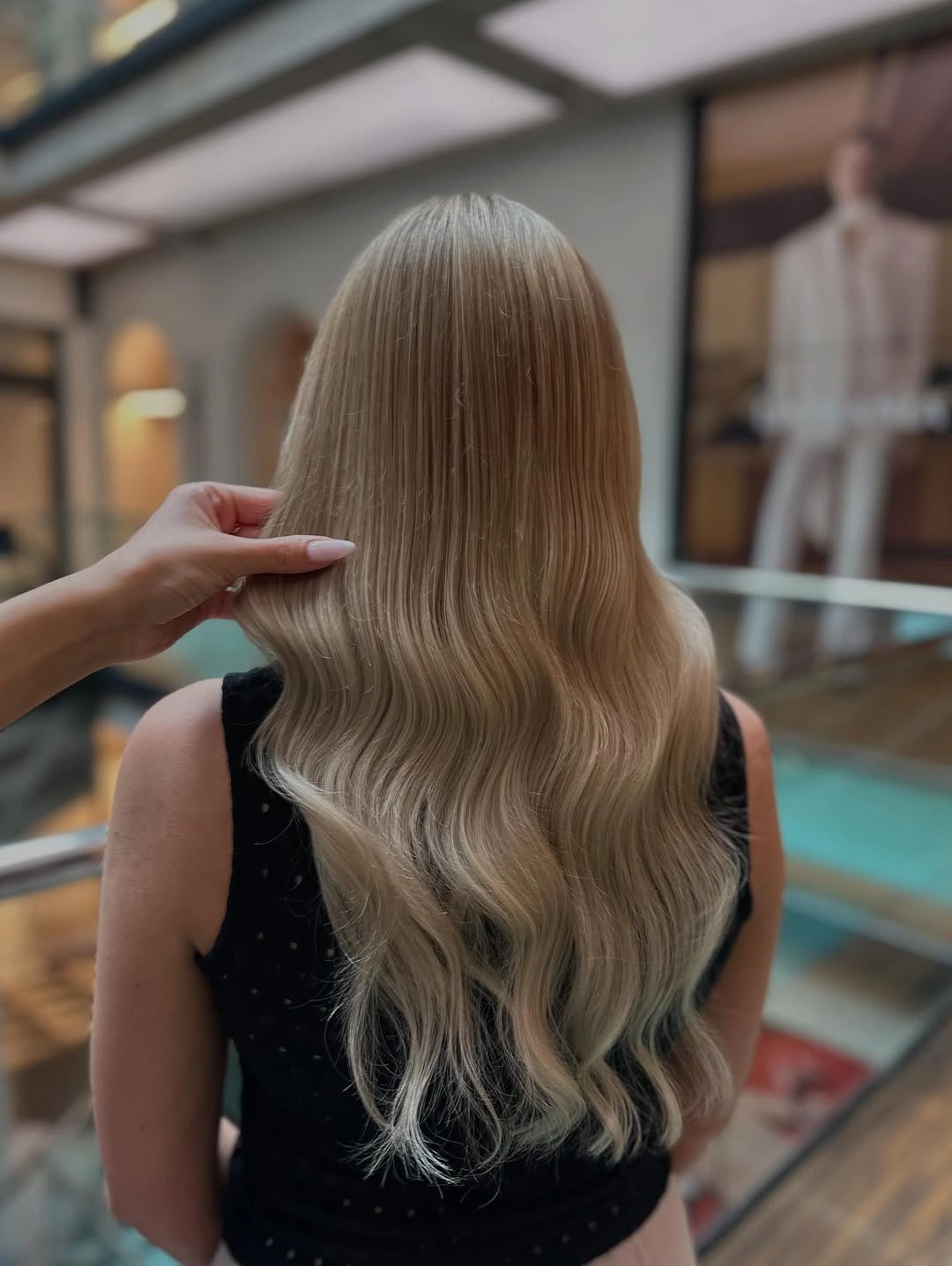 Long ash beige blonde waves with darker crown and lowlights