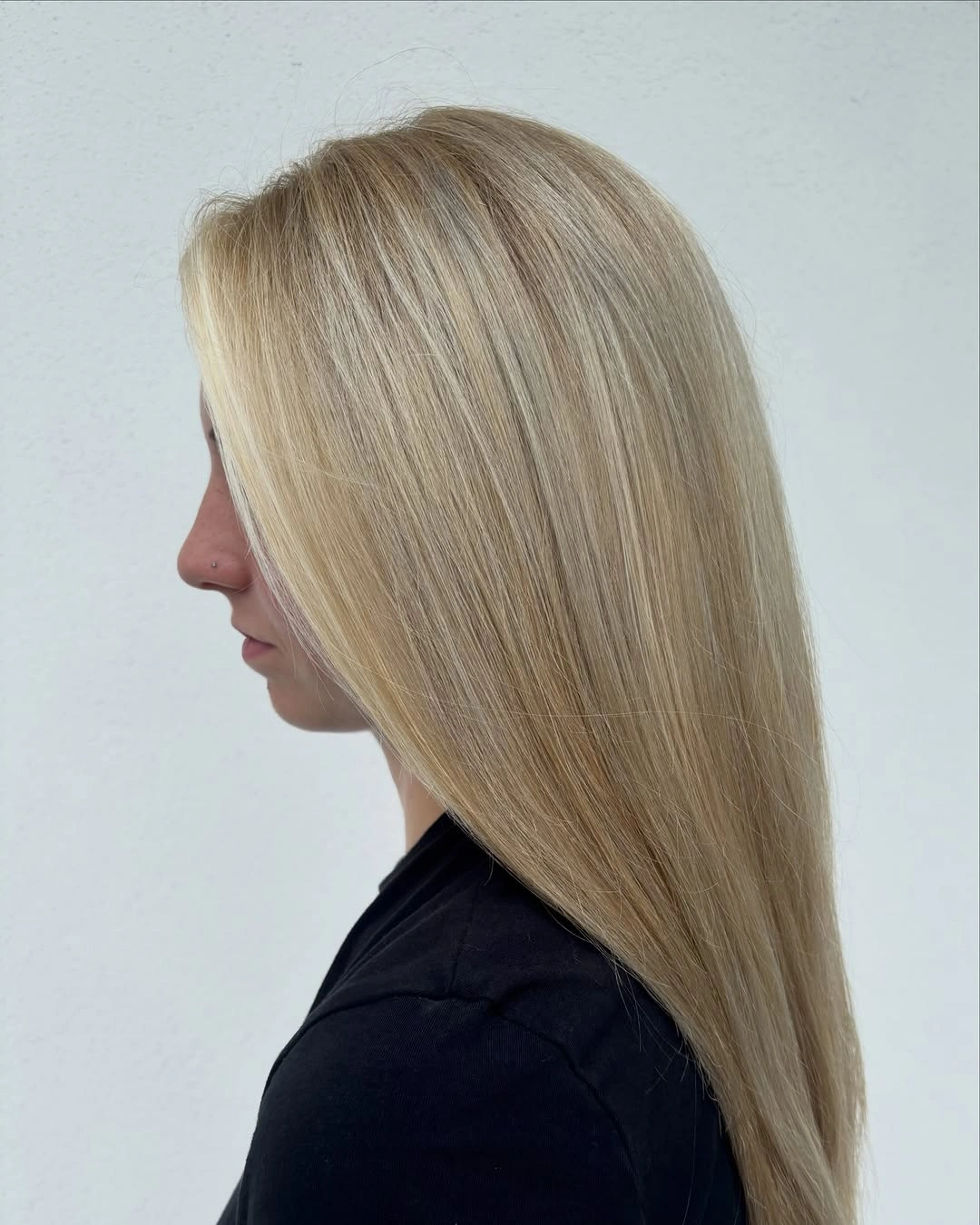 Long sandy blonde hair with subtle roots and smooth tapered length