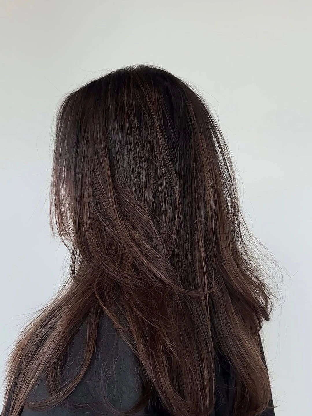Layered brunette hair with chestnut-brown ribbons and soft movement