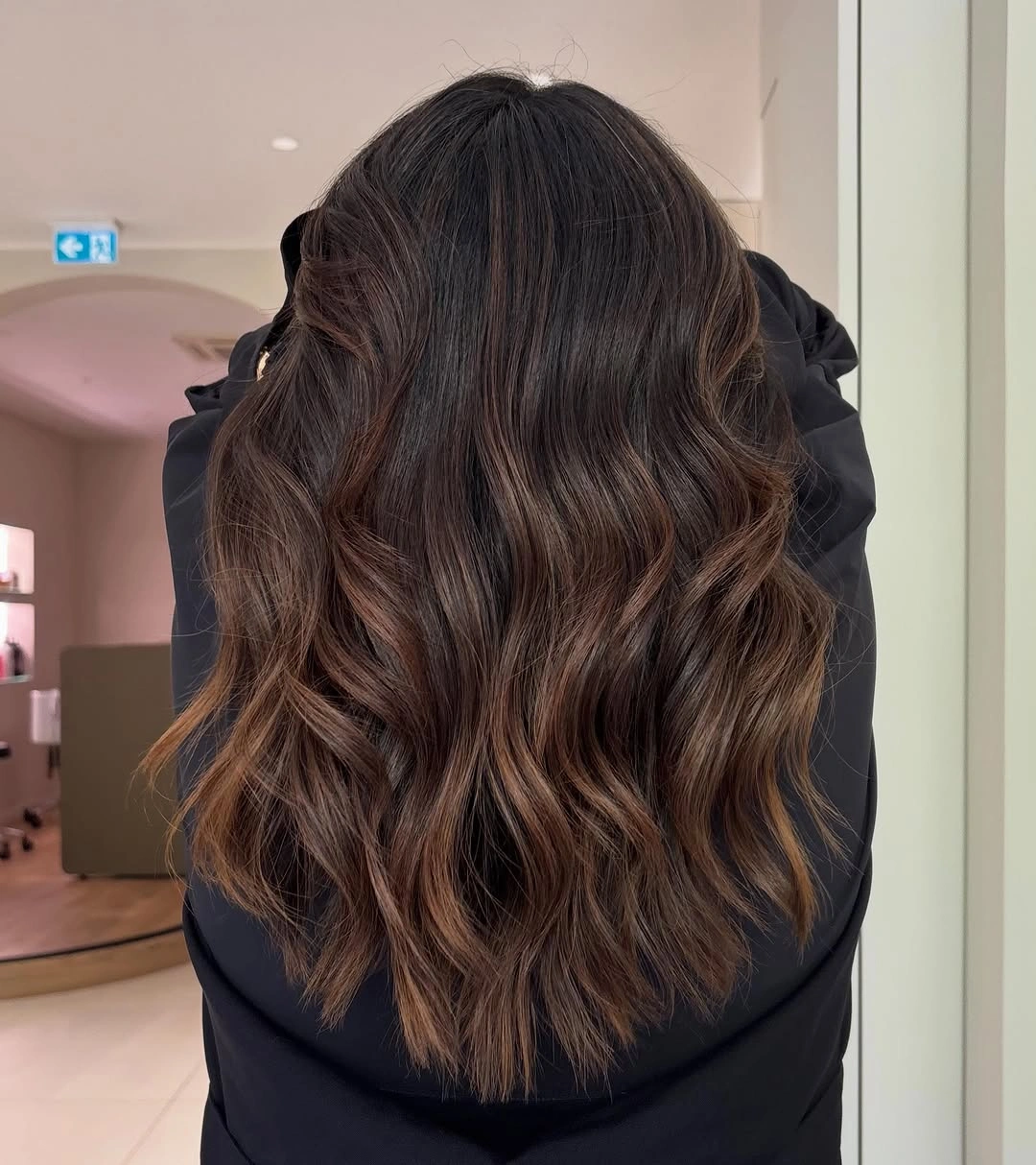 Wavy brunette hair with caramel ribbons from the back
