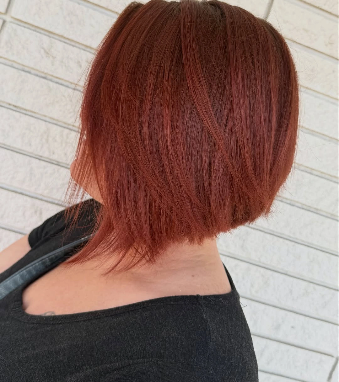 Short red-brown graduated bob with rounded crown and choppy nape