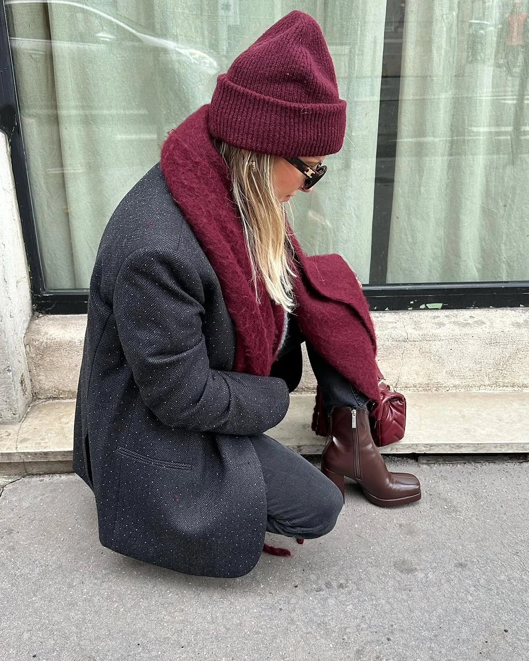 Charcoal coat with burgundy scarf, hat, gloves, and brown boots