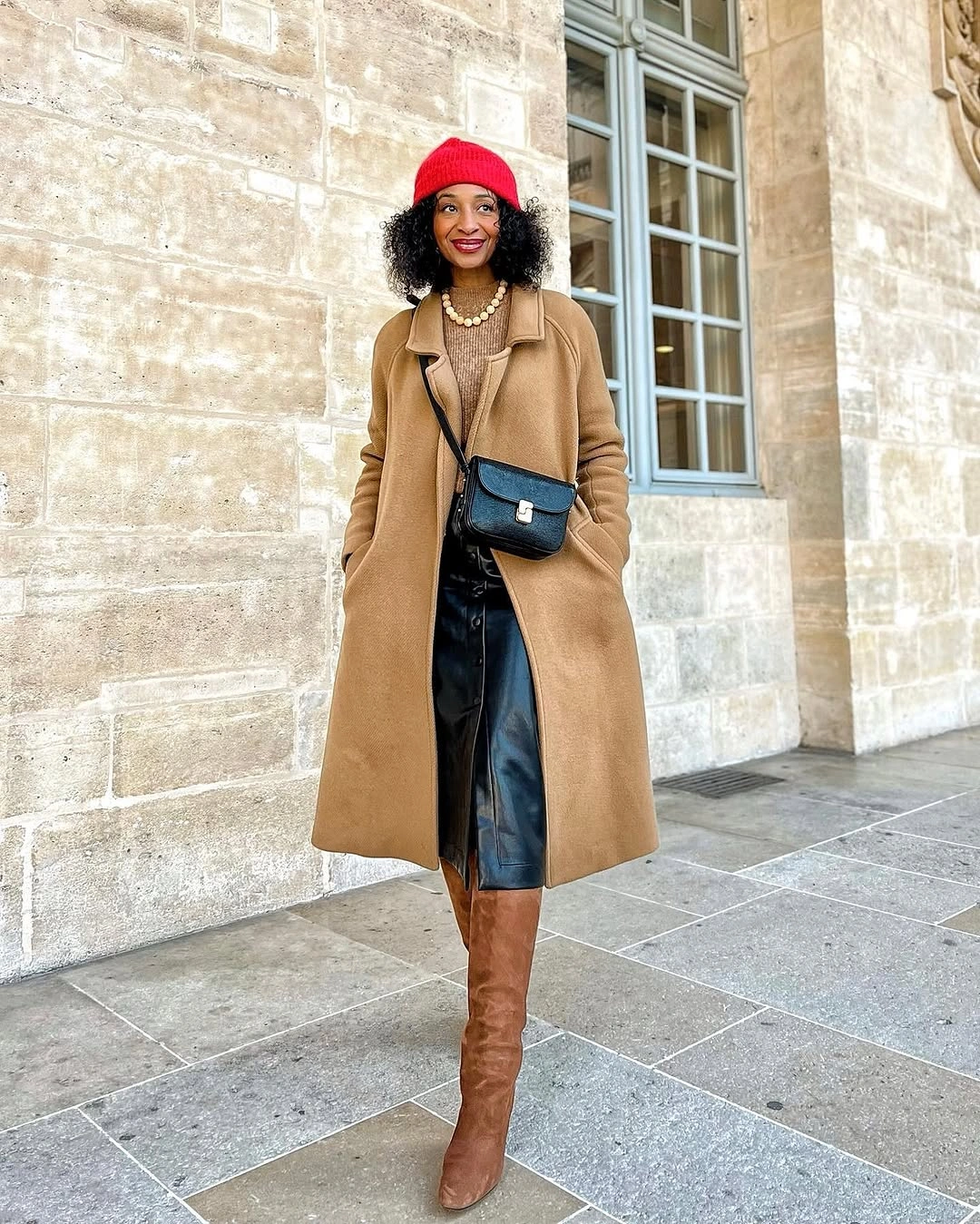 Camel long coat with red beret, tall brown boots, and black bag