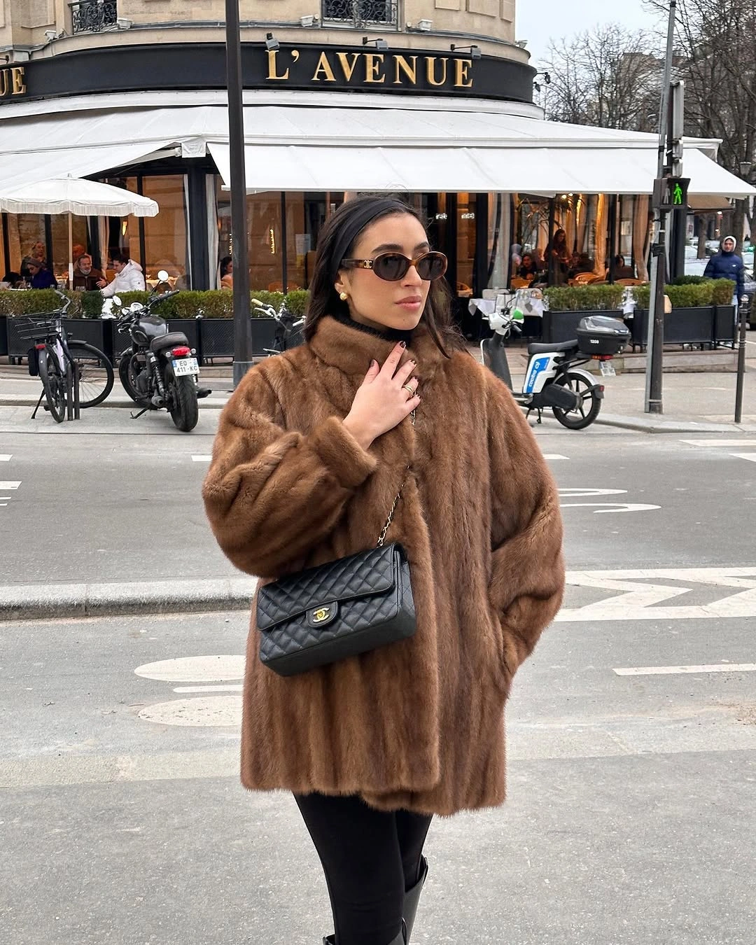 Warm brown textured coat with black trousers, sunglasses, and black crossbody bag