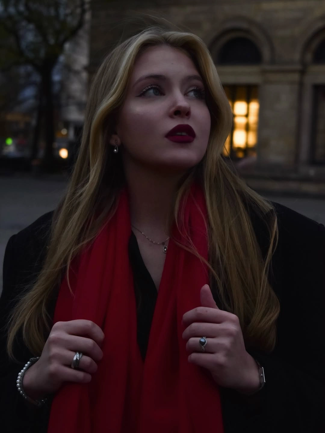 Dark outer layer with saturated red scarf and subtle jewelry details