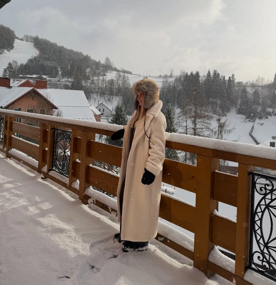 Long camel coat with knit hat, gloves, and dark layered clothes