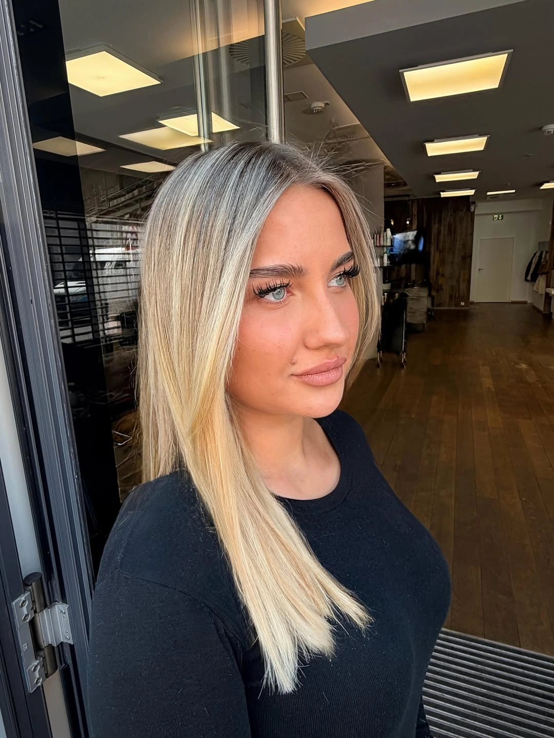 Long straight blonde falling diagonally over one shoulder