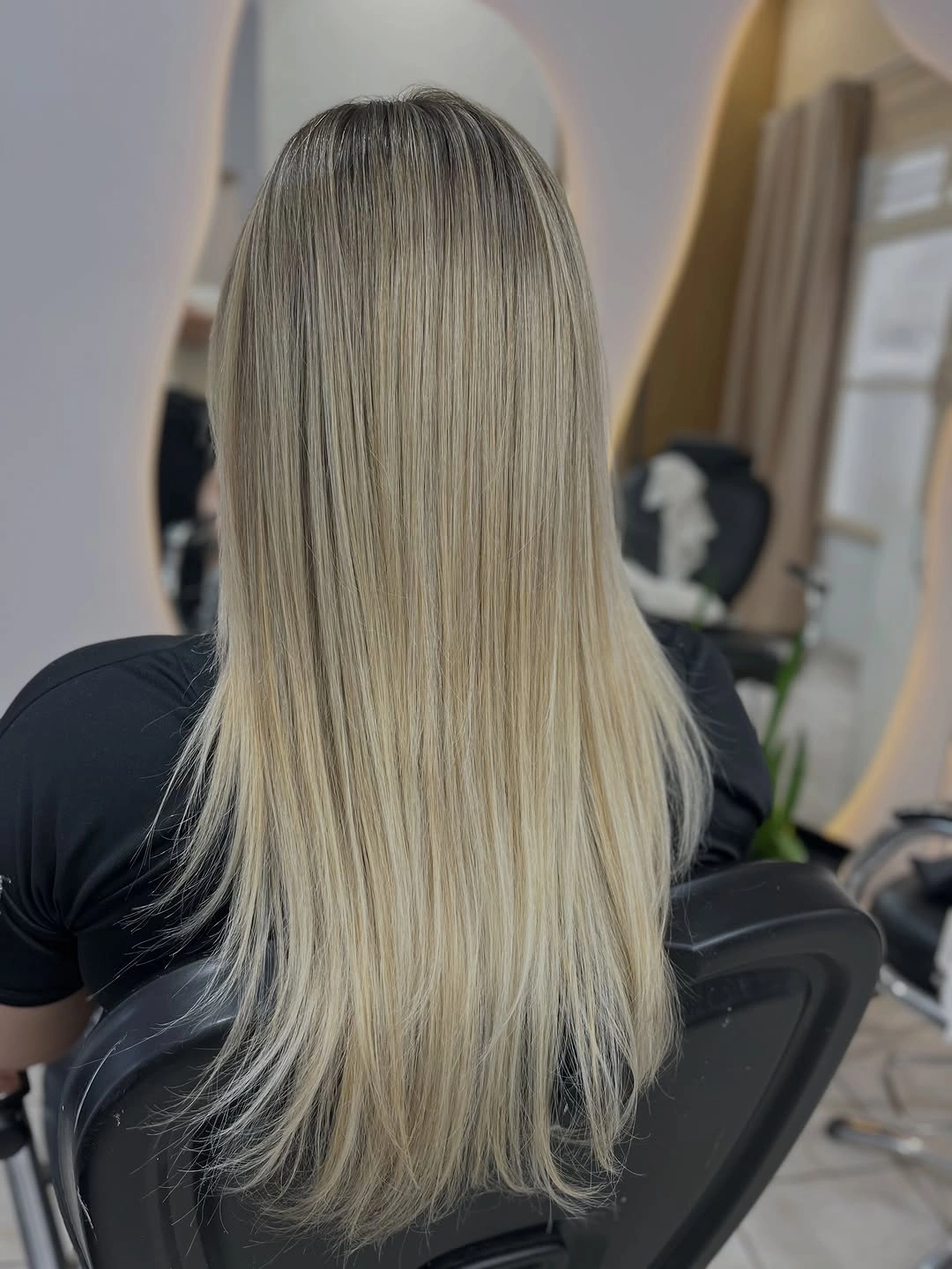 Long straight cool beige blonde with darker roots