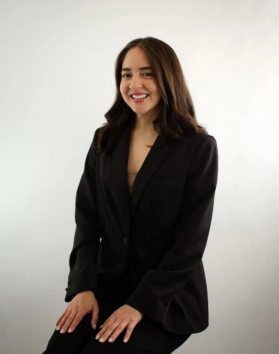 Black notched-lapel blazer with a front fastening and black trousers.