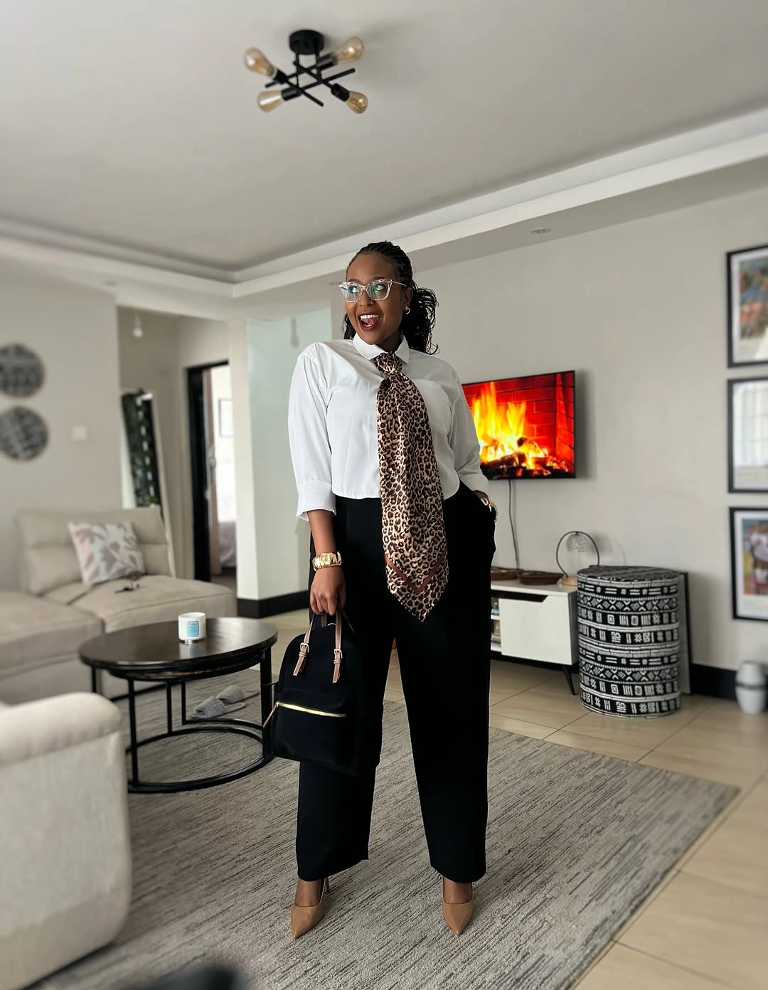 White collared shirt, long leopard-pattern neck scarf, black cropped trousers, and tan pointed shoes.