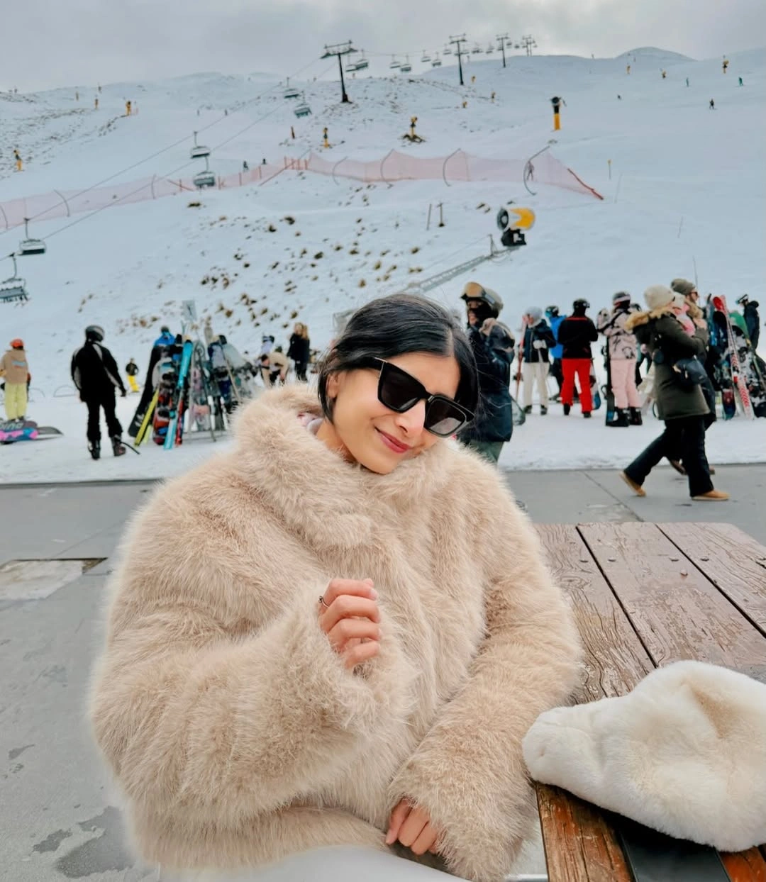 Pale textured coat with a large collar and dark sunglasses