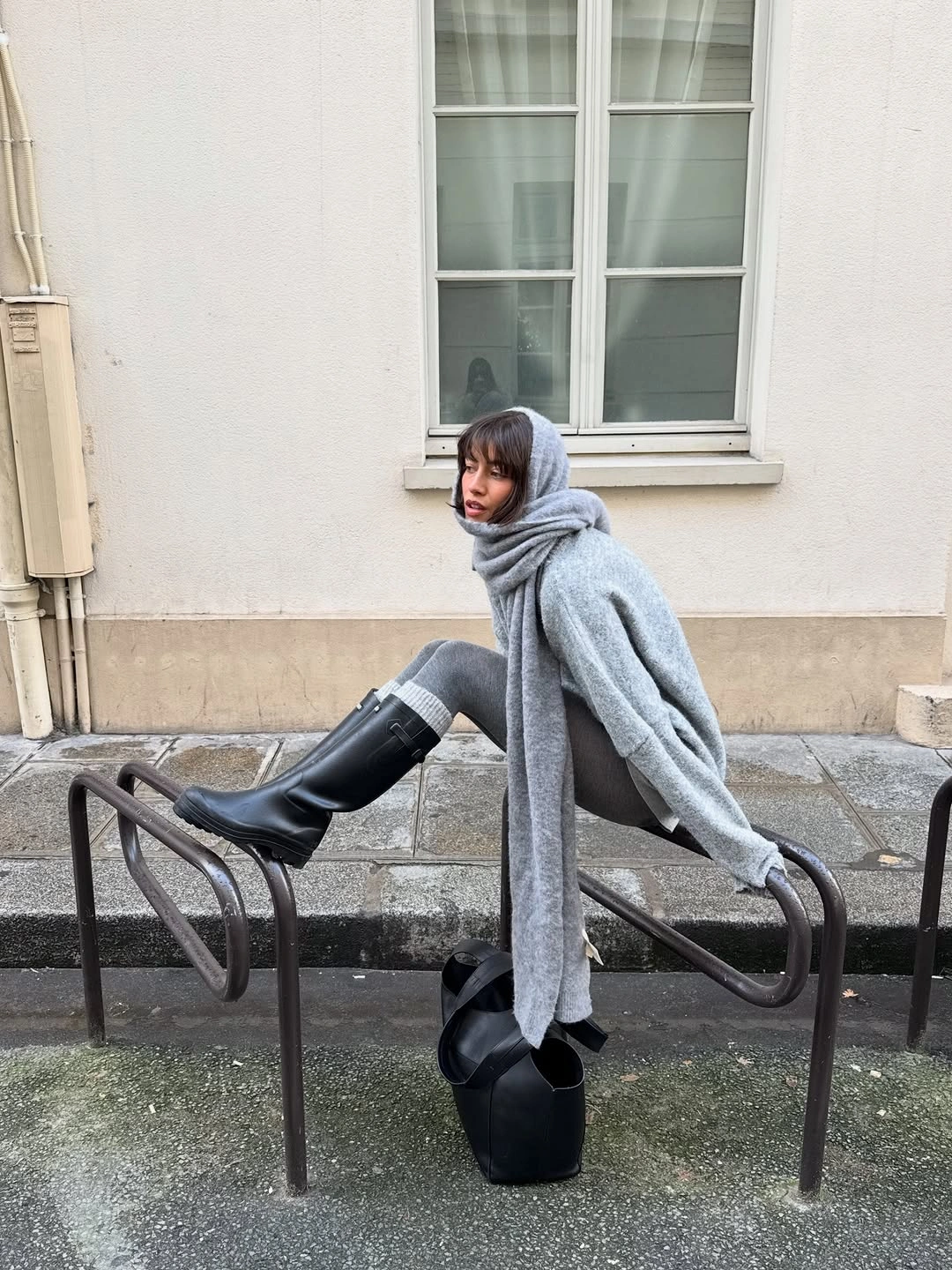 Light gray outer layer, long gray scarf, gray pants, black boots